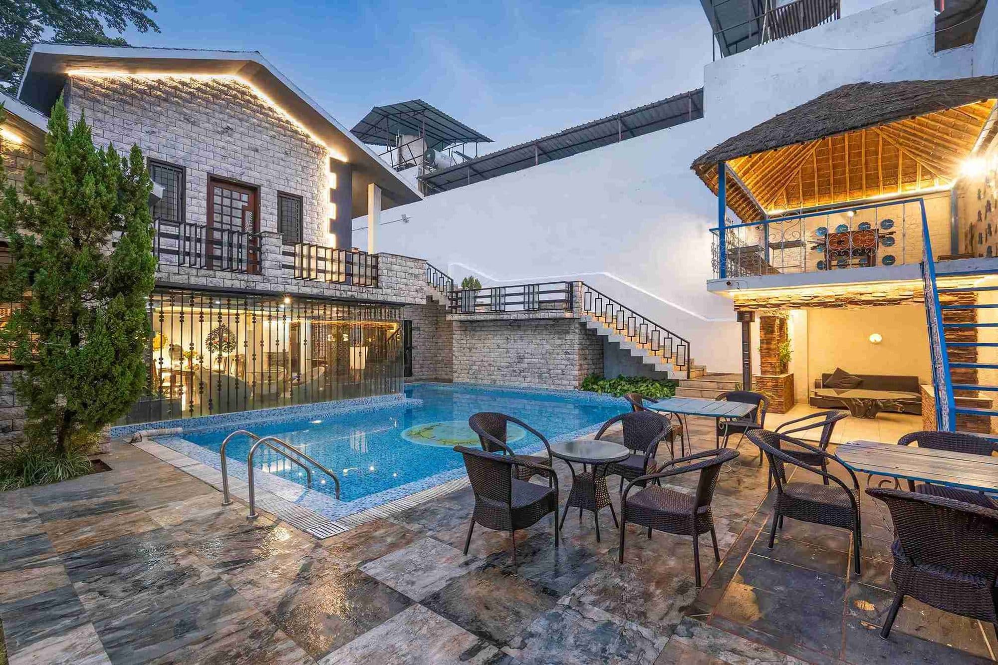 Amaltas Villa's pool terrace and lit verandas at dusk